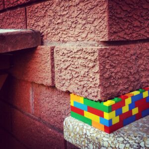Street art,colourful plastic blocks in brick wall